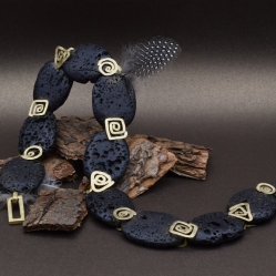 Een handgemaakt collier van lavasteen en 18 karaat geelgoud
